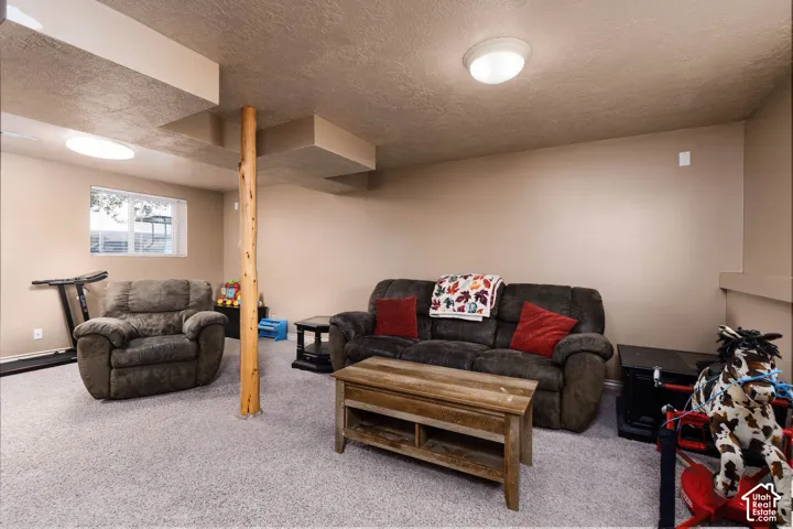 Carpeted room with recessed lighting, a structural wood column, and a window