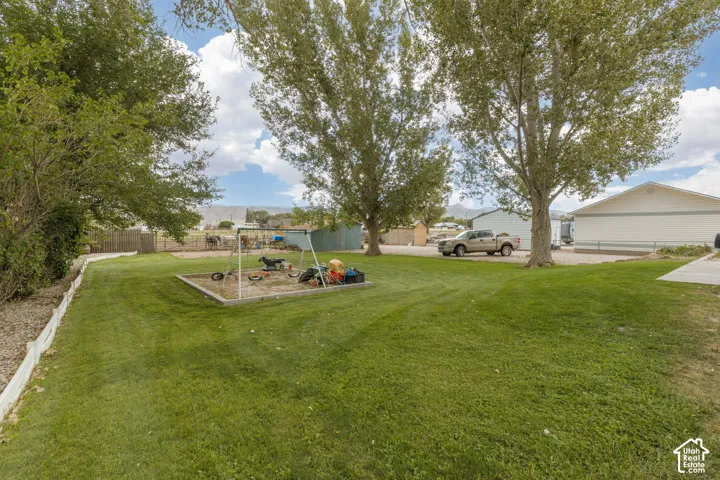 Expansive grassy yard with mature trees and a dedicated play area
