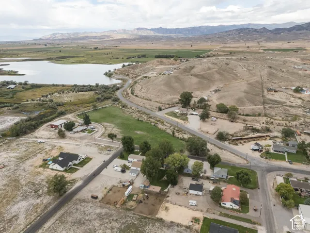 Expansive landscape featuring a large body of water, distant mountains, and varied terrain