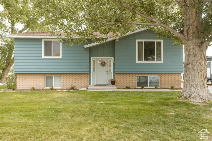 Split-level residence featuring a pastel blue siding and a light brick lower exterior