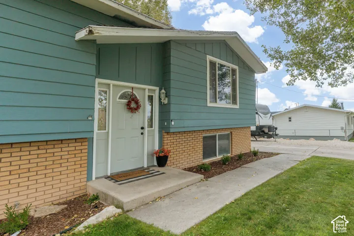 Light blue siding exterior with a brick foundation and white trim