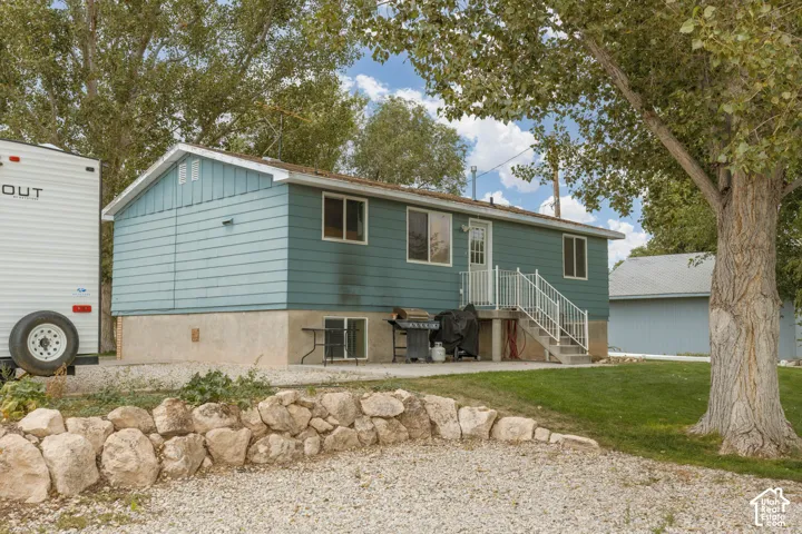 Blue siding exterior with white trim, concrete foundation, and white metal railings