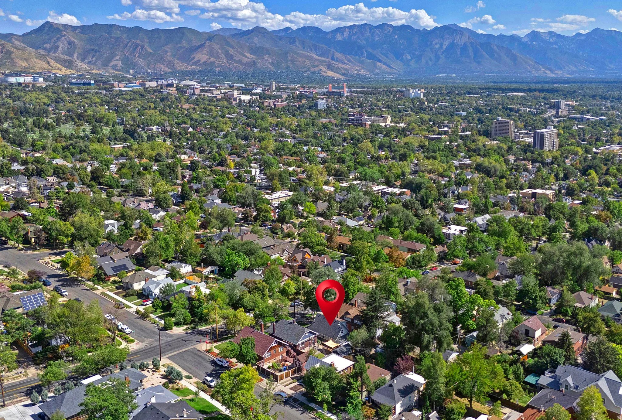 Mountain backdrop, mature trees, residential neighborhood, urban setting, clear skies