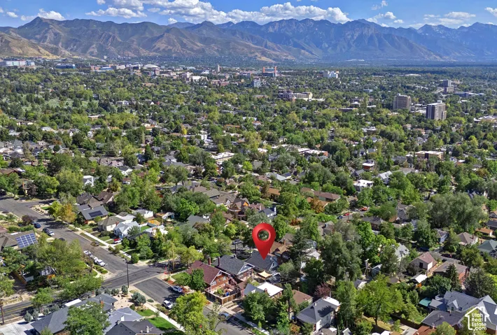 Mountain backdrop, mature trees, residential neighborhood, urban setting, clear skies