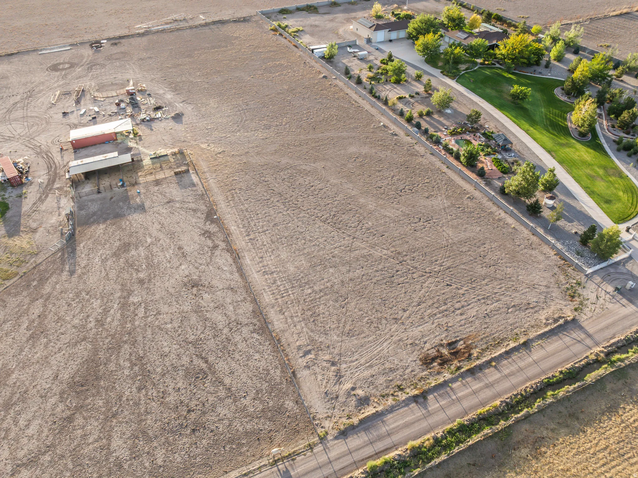 Expansive undeveloped land with a partial paved road boundary