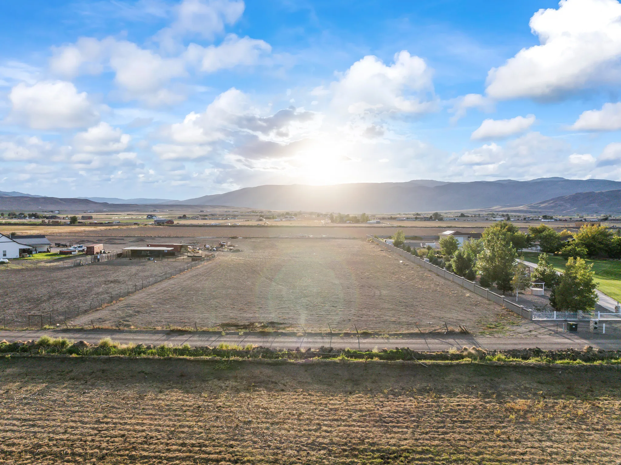 Expansive land parcel with surrounding mountain scenery and established trees