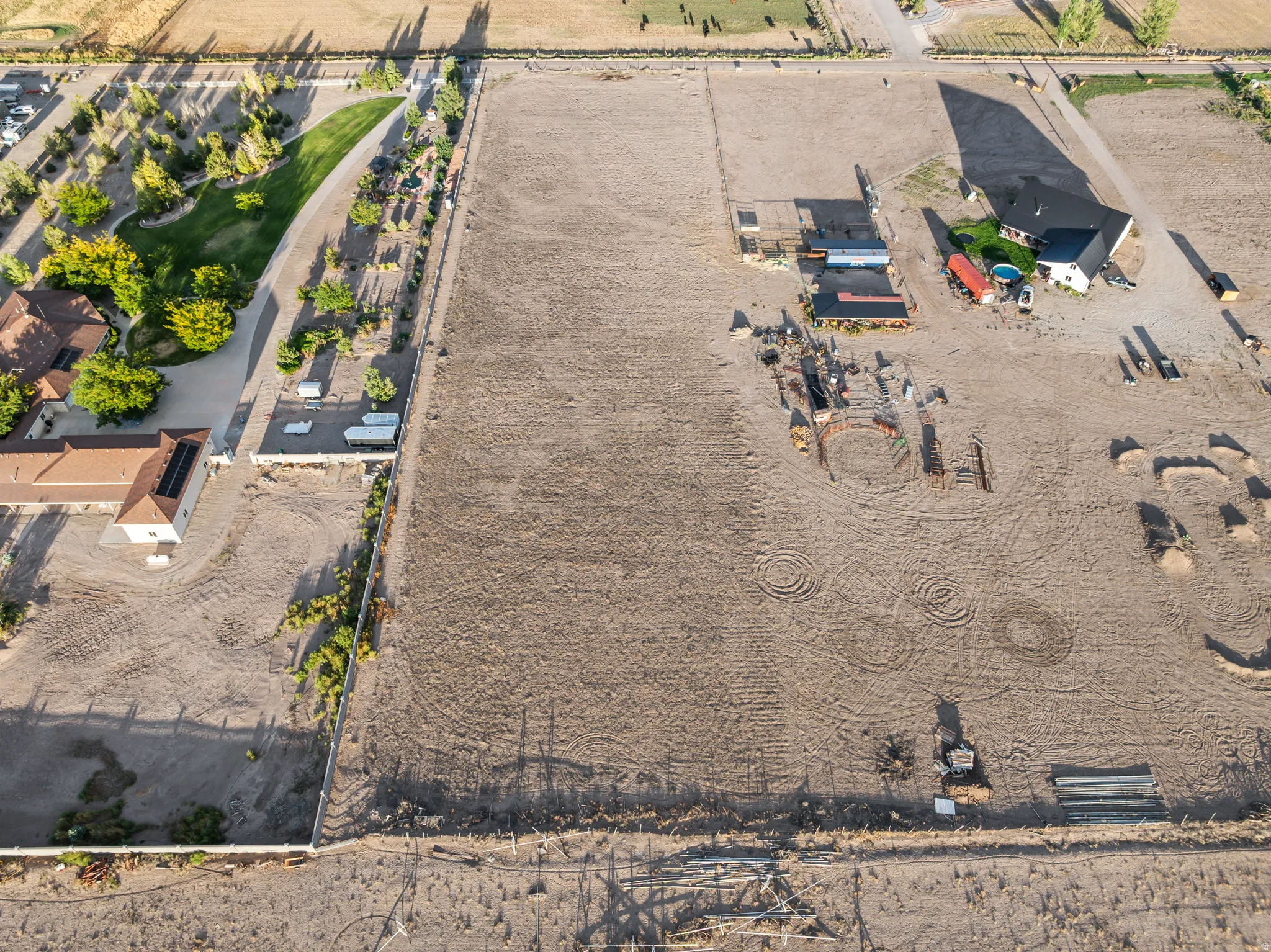Expansive land parcel featuring multiple structures, dedicated arena space, and adjacent landscaped driveways