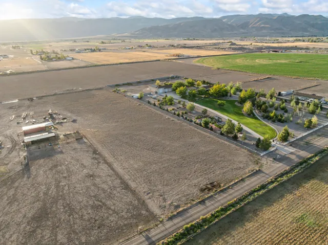 Expansive property featuring developed and undeveloped land, mature trees, manicured lawns, and distant mountain backdrops