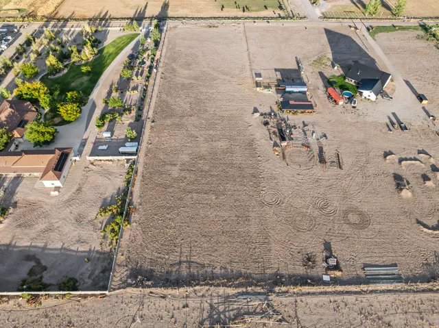 Expansive land parcel featuring multiple structures, dedicated arena space, and adjacent landscaped driveways