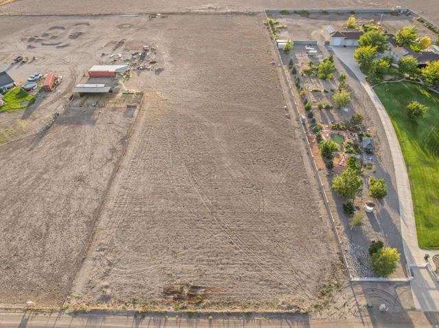 Expansive open lot featuring existing structures and cleared terrain