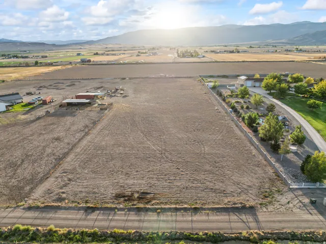 Expansive cleared lot with perimeter fencing and a defined gravel driveway