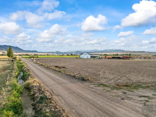 Expansive agricultural land featuring a dirt road and a drainage ditch