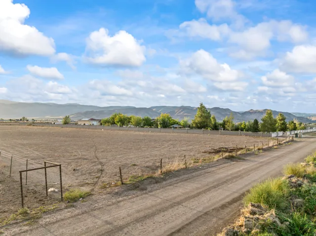 Expansive land parcel with surrounding mountain backdrop and distant structures