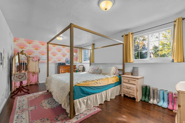 Wood-finish flooring, white walls with decorative wallpaper, and window with exterior views