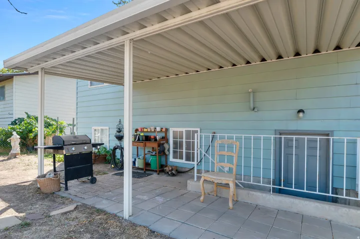 Patio area featuring a covered awning, tile flooring, exterior lighting, and a security railing