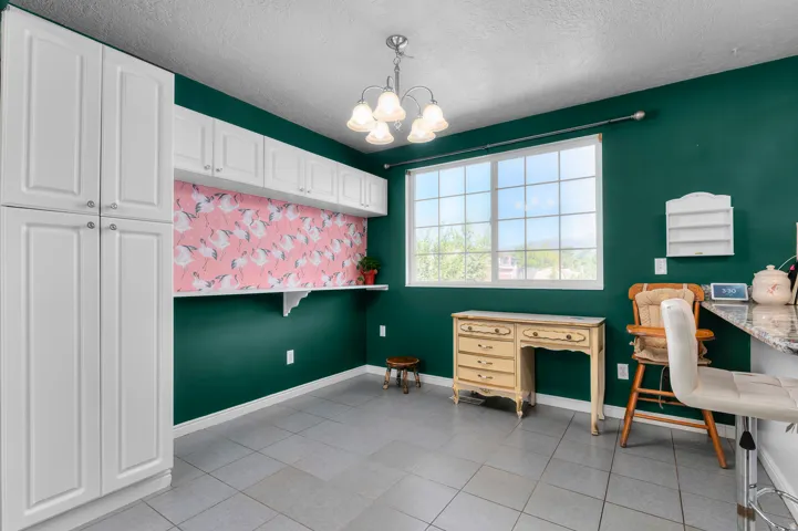 Built-in white cabinetry, overhead shelving, a transom window, and tile flooring