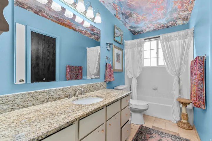 Vanity with a granite countertop, undermount sink, and brushed nickel faucet