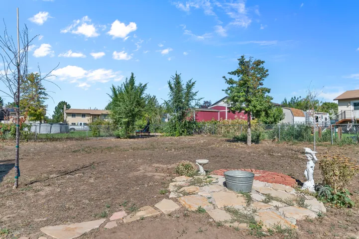 Expansive yard space featuring mature trees and a flagstone patio area