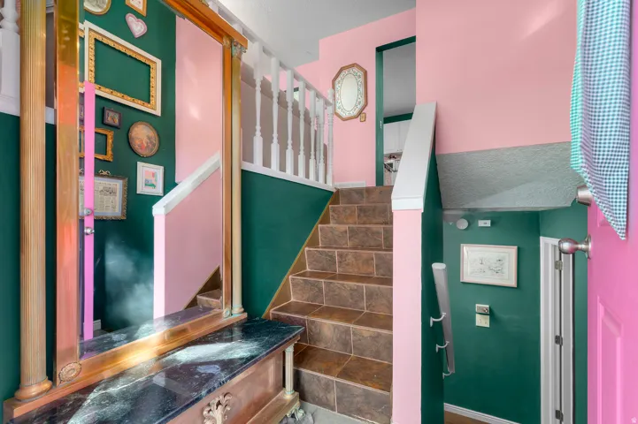 Tiled staircase with white balusters and a dark-finish newel post