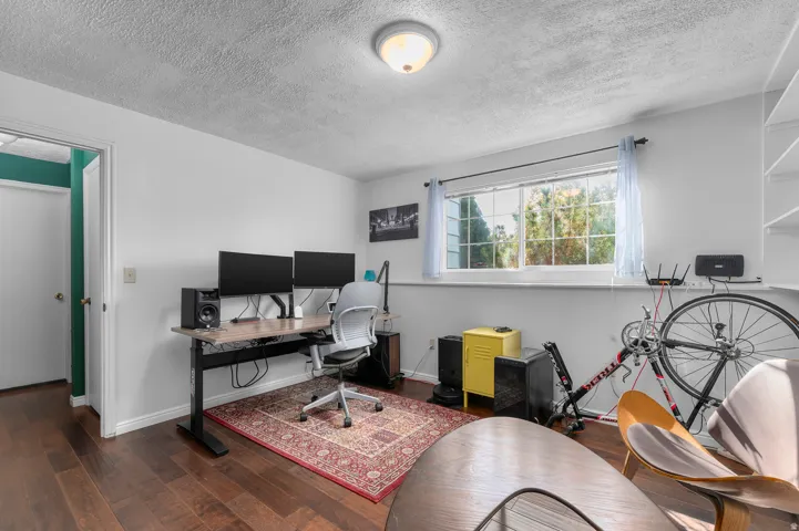 Wood-finish flooring, white walls, built-in shelving, and a prominent window
