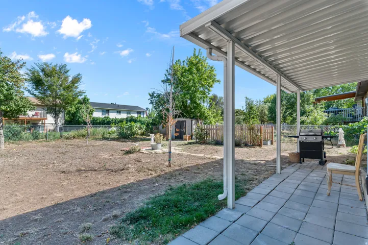 Covered patio with paver flooring and an expansive yard