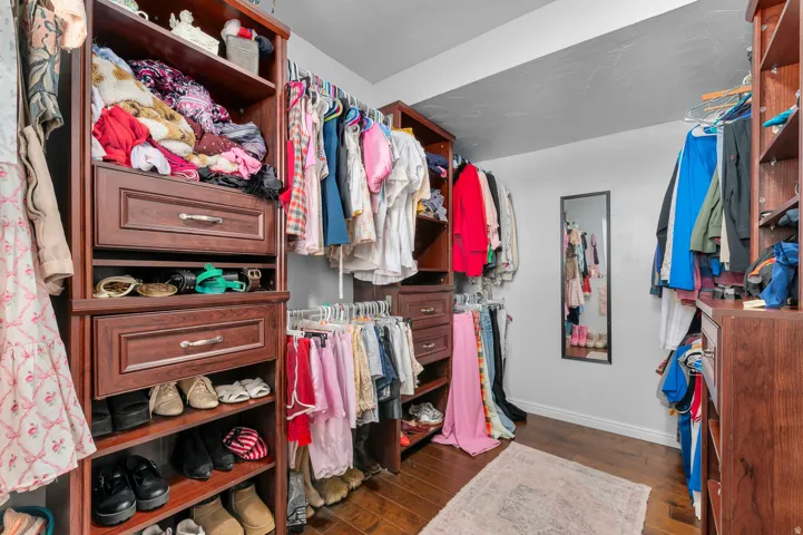 Custom closet system featuring built-in shelving, multiple hanging rods, and integrated drawers with brushed nickel hardware