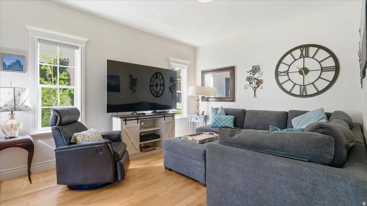 Hardwood flooring, white wall paint, white trim, and a white barn door-style media console