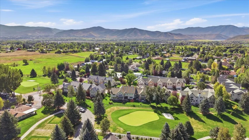 Residential area featuring golf course frontage, mature landscaping, and mountain backdrops