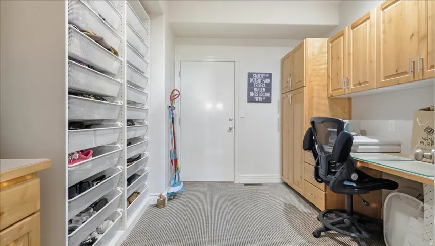 Built-in cabinetry with wood-finish doors, integrated desk space, and wall-mounted storage solutions
