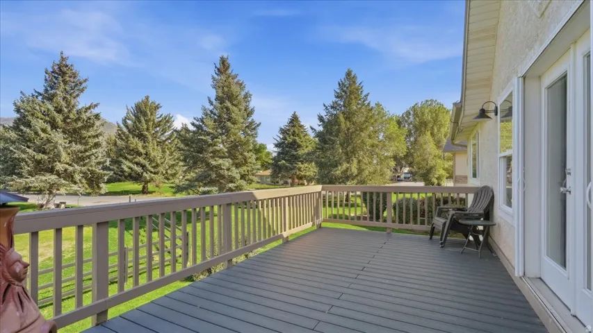 Expansive outdoor deck with wood railings, a durable deck surface, and direct access through a white double door
