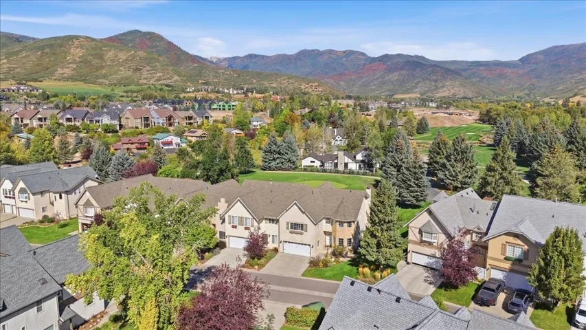 Townhome community with attached garages, mature landscaping, and mountain scenery