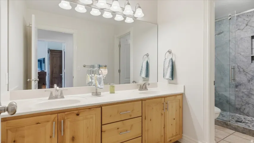 Double vanity with wood cabinetry and light-colored countertops