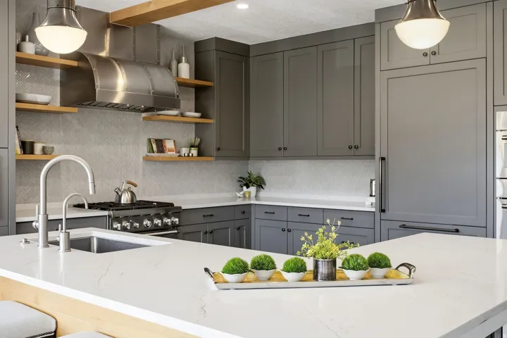 Spacious kitchen featuring an expansive island, stainless steel range with overhead hood, integrated refrigeration, and a tile backsplash
