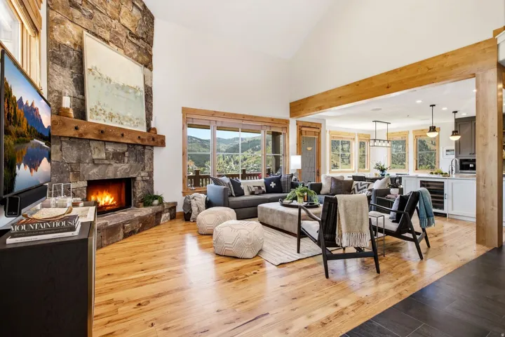 Vaulted ceilings compliment a stone-clad fireplace with a substantial wood mantel