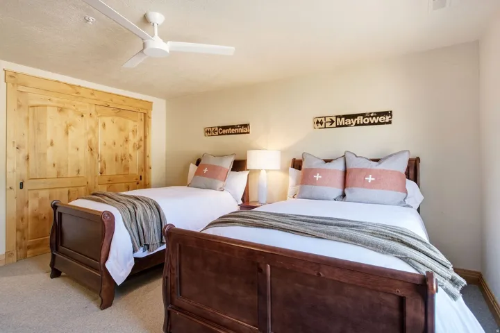 Ceiling fan with light fixture, natural wood-finish sliding closet doors, and neutral wall tones