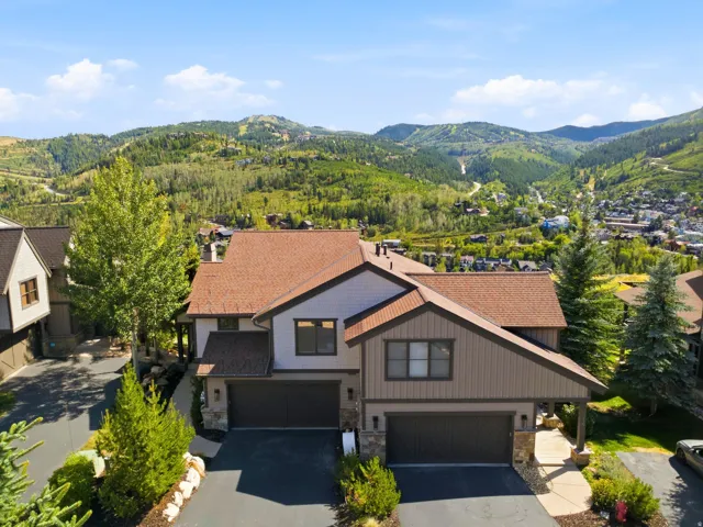 Two-story property featuring a multi-toned exterior, attached two-car garages, and a paved driveway