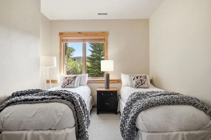 Neutral wall tones, wood-trimmed window, and integrated overhead lighting