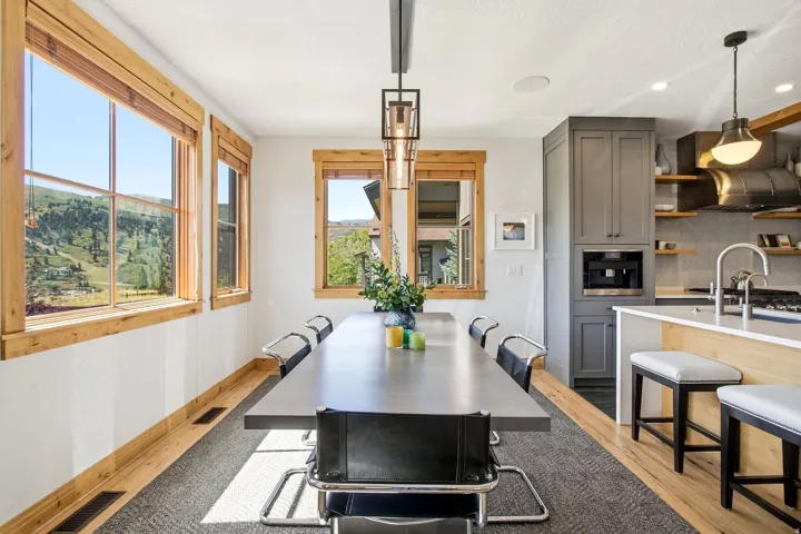 Kitchen and dining area featuring wood-finish flooring, custom cabinetry, built-in coffee maker, and recessed lighting