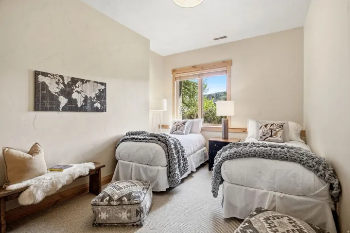 Carpeted room with a window featuring wood-finish trim, light-toned walls, and a ceiling-mounted light fixture