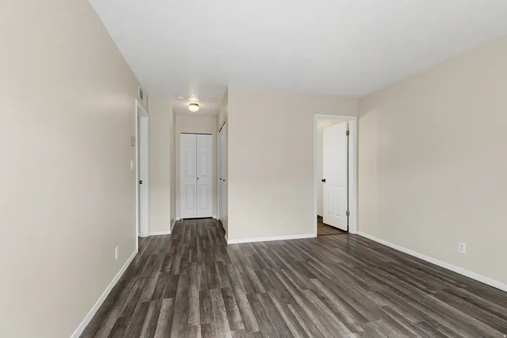 Wood-finish flooring throughout, smooth textured walls, white trim, and recessed lighting