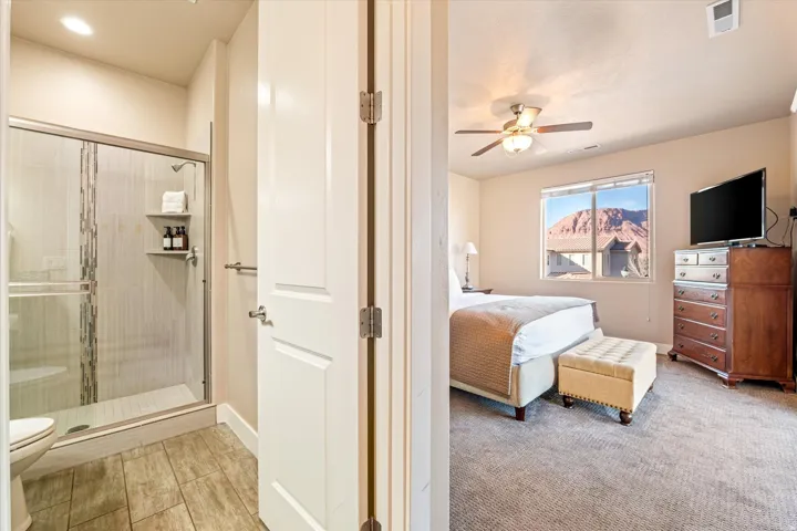Bedroom with a ceiling fan and a window with mountain scenery