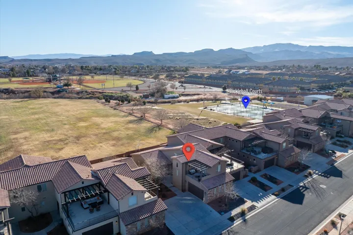 Terracotta tile roofing, stucco exterior, private upper-level patio, attached garage, and paved driveway