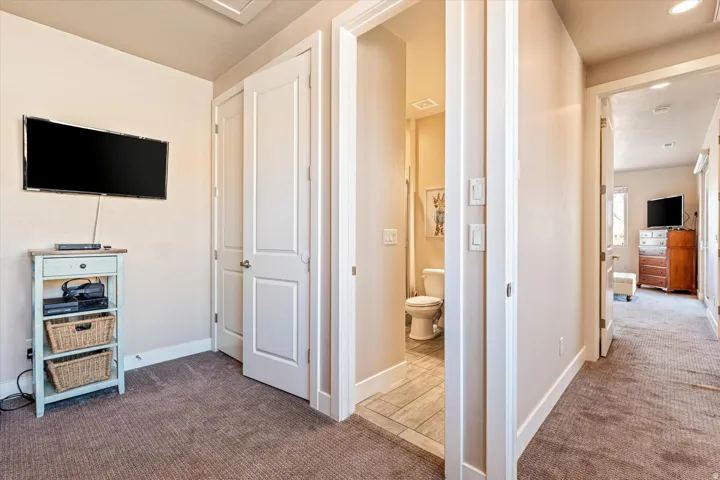 Textured carpeting, light-toned walls, white trim, and a white interior door