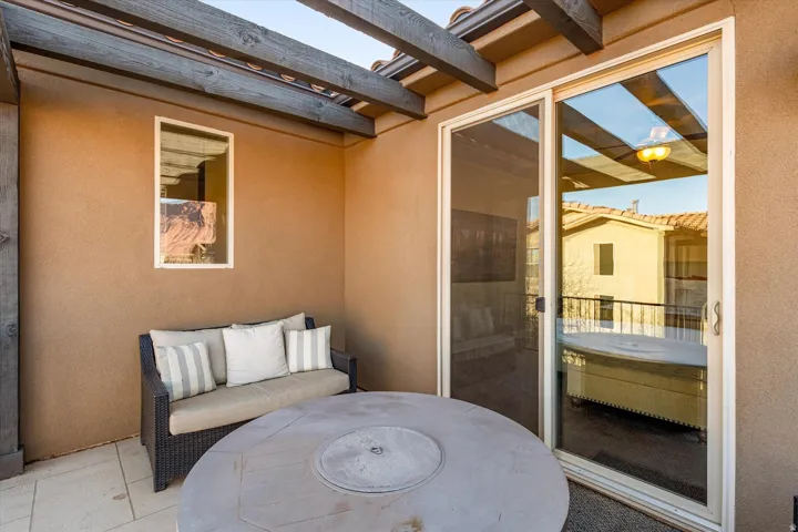 Private outdoor patio with stucco walls, wood pergola beams, and tile flooring