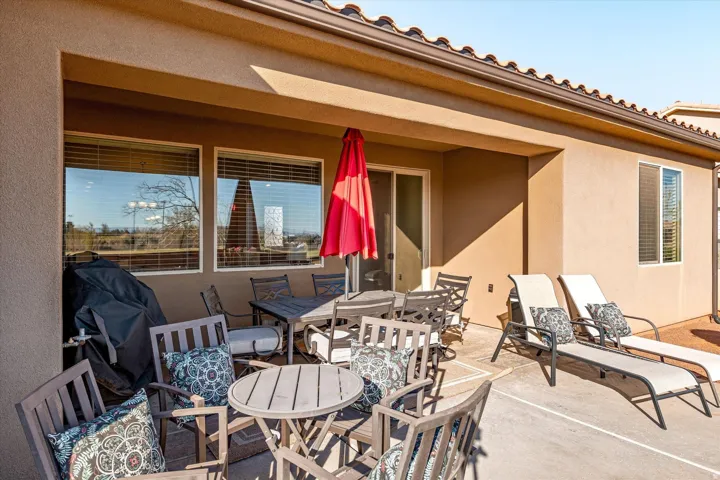 Covered patio featuring an extended concrete slab, multiple windows, and a sliding glass door