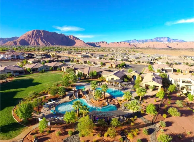 Community pools with water features, multiple covered pergolas, lush landscaping, and surrounding residential properties