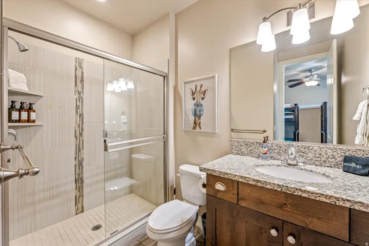 Glass-enclosed shower with tiled walls and an integrated shelf