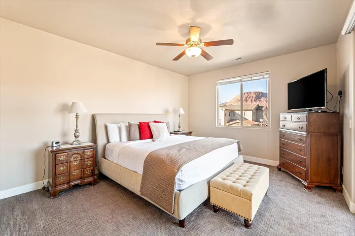 Carpeted room with a ceiling fan, a window, and neutral wall tones