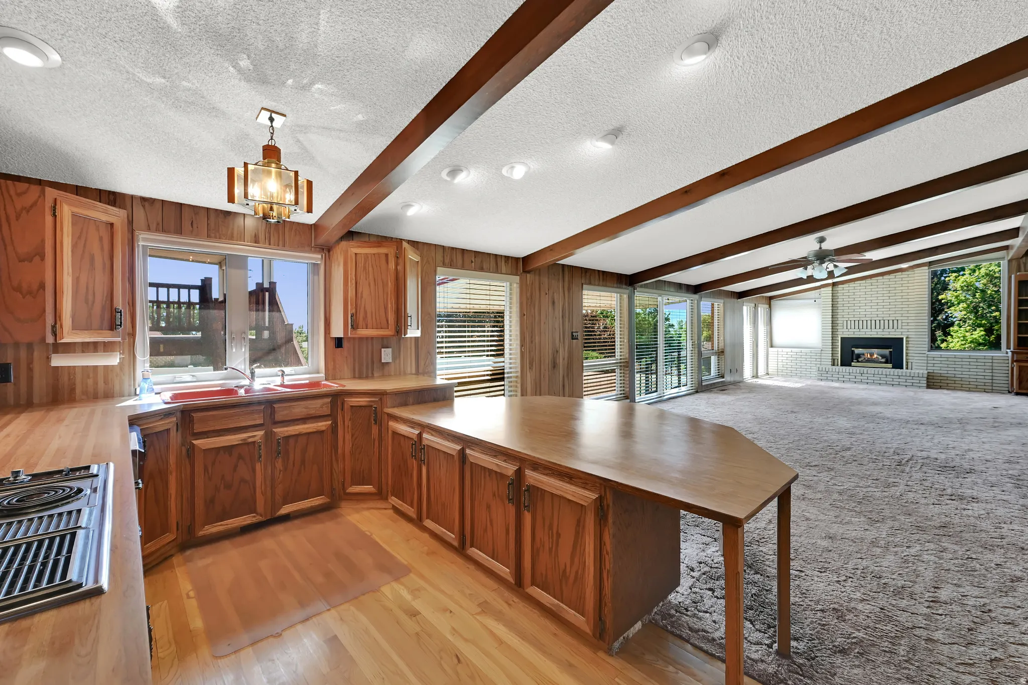 Kitchen with wood cabinetry, wood-finish flooring, and a built-in range