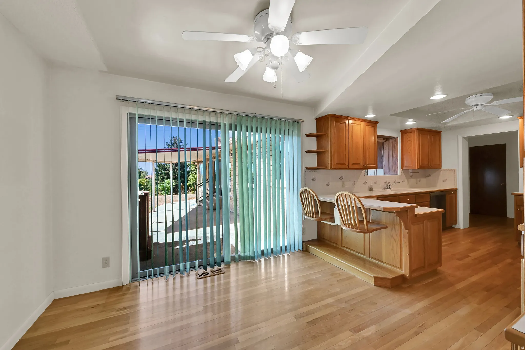 Wood-finish flooring throughout, with a built-in breakfast bar featuring two chairs